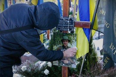 Eine Großmutter trauert auf dem Soldatenfriedhof in Lwiw am Grab ihres Enkels.
