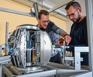 Daniel Garbe (links) und Nico Hille justieren die Achsen am Bearbeitungssystem Axisphere. 