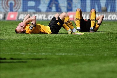 Dynamos Paul Will (li.) und Jakob Lewald liegen nach dem Nichtaufstieg niedergeschlagen auf dem Feld. 