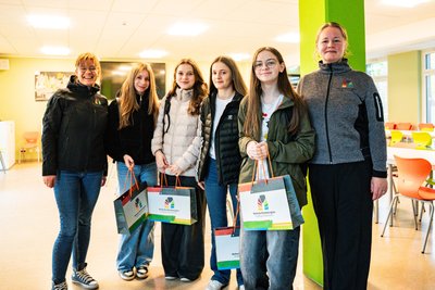 Kristin Hängekorb (l.) und Katharina Jesswein (r.) vom Welterbeverein übergeben vor der Abfahrt zum Pferdegöpel ein kleines Geschenk an Samira, Marie, Bena und Sarah (v.l.). Die Schülerinnen nehmen am Austausch mit der Partnerschule aus Pribram teil.