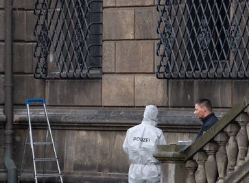 Polizisten neben dem durchtrennten Gitterfenster des Grünen Gewölbes am Residenzschloss.
