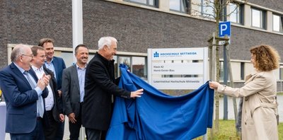 Horst Exner (Bildmitte) enthüllt den neuen Namen des Forschungsbaus am Laserinstitut Hochschule Mittweida. 