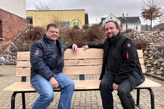 700-Jahr-Fete steht bevor: Dieser Reichenbacher Ortsteil will „das größte Fest der Dorfgeschichte“ feiern - Ortsvorsteher Veit Bursian (l.) und Christian Dillner, Leiter des Festkomitees, auf einer Bank, die anlässlich der 700-Jahr-Feier in Rotschau durch die Metalltechnik Tiepner und die Tischlerei Z-Schnitt gesponsert wurde. Sie ist aus Eichenholz aus dem Aussichtswald gefertigt worden.
