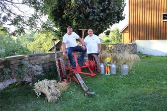 700 Jahre Zethau: Handwerker- und Bauernmarkt findet am Samstag statt - Frank Uhlmann (l.) und Michael Timmel, hier neben einer Haumaschine auf dem Bauernhof Weidensdorfer, organisieren den Handwerker- und Bauernmarkt am Samstag in Zethau. Auch eine Schau landwirtschaftlicher Technik gehört zum Programm.