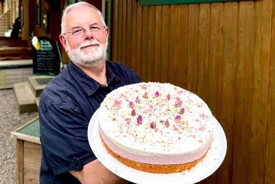 Roland Heldt vom Talsperrencafé in Lichtenberg/Erzgebirge mit einer Rosen-Erdbeer-Torte.