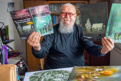 Aus dem Atelier an den Kiosk: Ralf Alex Fichtner mit den Heften der Serie "Professor Zamorra" aus dem Bastei-Verlag und den Bildern, die dafür verwendet wurden. Mehr Horror-Stoff liegt auf seinem Schreibtisch.