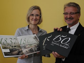 Mitarbeiterin Hanka Michel und Verwaltungsdirektor Rainer Leischker präsentieren die druckfrische Chronik des Krankenhauses.