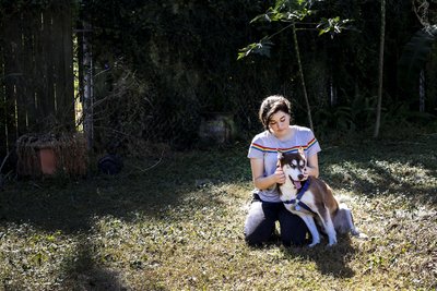 Fidnerin Rose Verrill streichelt den Kopf eines braun-weißen Husky namens Sinatra in ihrem Haus.