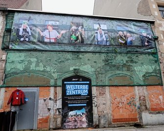 Ein Banner kündet an den Resten der Fassade des Hauses Petersstraße 19, dass hier das künftige Freiberger Welterbezentrum entstehen wird. Das Gebäude rechts daneben wird dabei mit einbezogen. 