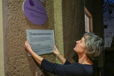 Anja Hüttner von der „Lila Villa“ zeigt den Ort, wo die Menschenrechtstafel aufgehängt werden soll.