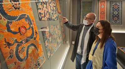 Jochen Wolf und Julia Endemann schauen sich die ausgestellten tibetischen Teppiche der neuen Sonderschau im Museum auf Schloss Voigtsberg in Oelsnitz ganz genau an. 