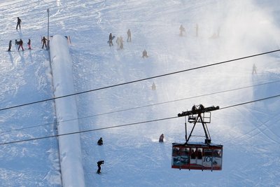 Am Fichtelberg läuft der Skibetrieb mittlerweile auf Hochtouren: Blick auf die Fichtelberg-Schwebebahn, während Wintersportler auf der Piste unterwegs sind.