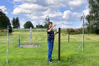 Der Hobby-Meteorologe an seiner Wetterstation: Beim sogenannten Hellmann-Regenmesser wird die Regenmenge noch händisch abgelesen. Links im Bild sieht man die moderne Variante: ein automatischer Niederschlagsmesser.