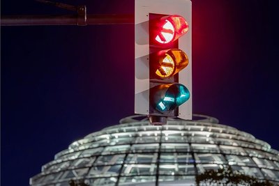 Eine Ampel leuchtet in Langzeitbelichtung - im Hintergrund die Reichstagskuppel: SPD, Grüne und FDP sondieren derzeit, ob es für eine Regierungskoaliton reicht. 