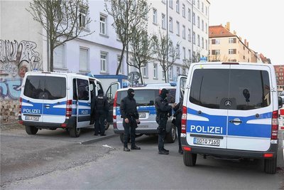 Einsatzkräfte bereiten sich auf die Durchsuchung der Wohnung eines Mannes vor. Er soll an den Ausschreitungen beteiligt gewesen sein.