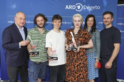 ARD-Degeto-Geschäftsführer Thomas Schreiber mit den Gewinnern des Killerstories Series Award - Valentin Burkhardt und Arvid Klapper sowie Josy Scheffler - und Carolin Haasis und Johannes Hauer (v. l. n. r.) von der ARD Mediathek. 
