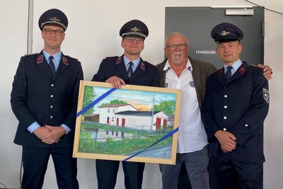Helmut Weller übergab der Ortsfeuerwehr ein Bild mit der Ansicht des alten Gerätehauses.