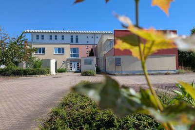 Das Gebäude verfügt auch über ein großzügiges Außengelände, vorne befindet sich ein Parkplatz.
