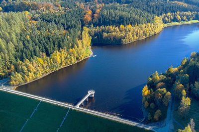 Bunte Laubbäume schmücken das Ufer der Talsperre. Dabei fällt aus der Vogelperspektive der niedrige Wasserstand kaum auf.
