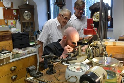 Seit 65 Jahren betreibt Familie Gläser in der Freiberger Burgstraße Uhrmacherwerkstatt und Geschäft, nun in zweiter Generation. Im Bild schauen Geschäftsgründer Johannes Gläser (Mitte) und der jetzige Inhaber Holm Gläser Uhrmacher Richard Schade über die Schulter. 