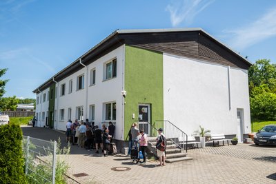 Geduldig stehen Menschen an der Ausgabe der Tafel in Lugau an.