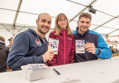 Nach dem Wettbewerb konnten Besucher Autogrammkarten von berühmten Sportlern signieren lassen. Im Bild: Im Bild: Brett Flemming, Fan Nele Beck aus Oberschmiedeberg, und Juraj Valach von der Eishockeymannschaft Pirati Komotau. 