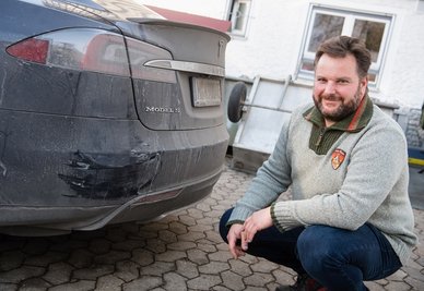 Retter Manfred Kick am demolierten Heck seines Teslas.