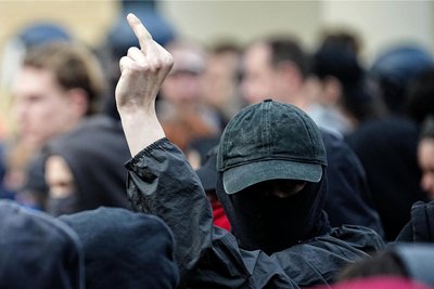 Gegen die Polizei, gegen den Staat: Bei einer Demonstration von Linksradikalen in Berlin zeigt ein Mann eine eindeutige Geste.