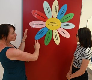Zu Lebenskompetenzen hat Schulsozialarbeiterin Mary Köhler (l.) eine Blume gestaltet. Diese Kompetenzen will sie den Schülern der Oberschule Zschorlau wie der zwölfjährigen Annika Schwarz vermitteln. 