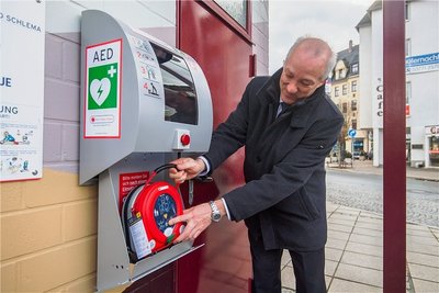 Die ersten Defibrillatoren des Projekts "Herzsichere Stadt Aue-Bad Schlema" sind übergeben worden. Thomas Pflanz, der Projektkoordinator von "Herzsicher", schaut sich das Gerät am Auer Postplatz an. 