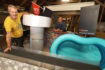 Blick zurück: Silvio Fleischer (l.) und Nico Kretzschmar inmitten ihres Freibad-Bildes mit Talsperre für den Umzug zum Dorffest 2025 in Lichtenberg.