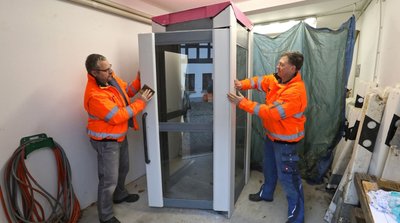 Aus einem Telekom-Lager in der Nähe von Potsdam stammt die Telefonzelle, die derzeit in Schönberg von den Bauhof-Mitarbeiter Frank Steiniger (links) und Karsten Pätzold zu einem Bücherschrank umfunktioniert wird. 