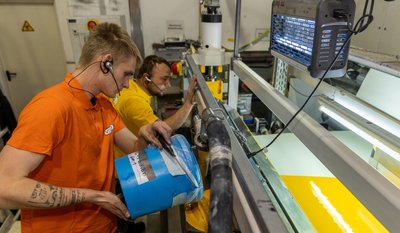 Bei Vowalon in Treuen wird nicht nur Kunstleder produziert, es werden auch Stoffe gefärbt. Hier bringen Marcus Haubold (hinten) und Tobias Beck Spezialfarbe in eine Beschichtungsmaschine ein. 