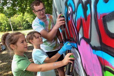 Max Kagerer, Erzieher an der Karl-Marx-Grundschule, teilte in einem Graffiti-Workshop sein Hobby mit Kindern - hier Lisa Becher (7) und Hannes Hofmann (9). 