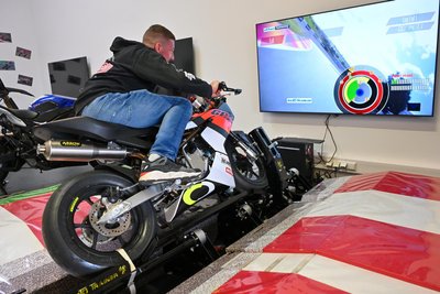 Oliver Jentsch auf einem Motorrad-Simulator mit dem Streckenverlauf des Sachsenrings.