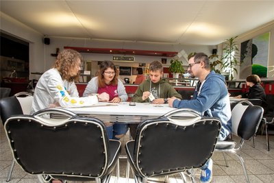Wer mogelt? Frederik, Tamara und Andreas (von links) spielen Karten mit Boxenstop-Chef Pascal Ulbrich.