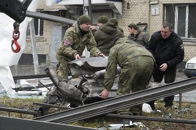 rbeiter räumen die Trümmer einer Rakete auf einen Lastwagen, nach einem russischen Beschuss. Russische Truppen haben am Donnerstag, 24.02.2022, den erwarteten Angriff auf die Ukraine gestartet.