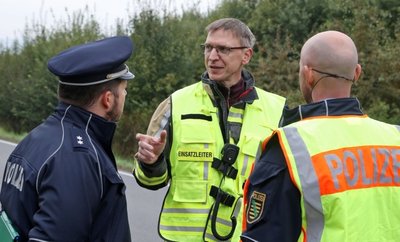 Einsatzleiter Dirk Werner (Mitte) von der Freiwilligen Feuerwehr Gersdorf stimmt mit den Polizisten die Maßnahmen nach der Bergung ab.