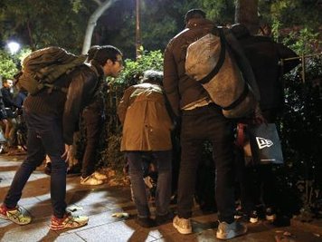 Passanten stehen in der Nähe der Konzerthalle «Bataclan» in Paris.