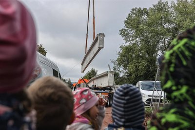 Spektakulärer Zwischenschritt: Im September 2022 wurden die Binderelemente, die Träger der Dachkonstruktion, mit einem Kran auf die Stützen der Sporthalle Niederwiesa gehoben.