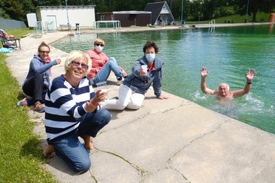 Prost: Sylvie Weißflog und Heike Löffler (hinten v. l.) sowie Gisela Schüler und Monika Horlbeck (vorn v. l.) stießen am Pfingstsamstag mit einem Becher Sekt auf die Saisoneröffnung im Freibad Netzschkau an. Im Wasser: Siegfried Schüler. 