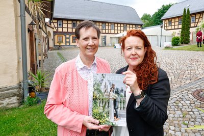 Sabine Günther (links) und Mandy Neupert mit dem aktuellen Hochzeitsmagazin auf dem Denkmalhof in Schlagwitz.