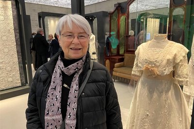 Beate Schad steht vor ihrem Lieblingsstück. Es ist ein fast 120 Jahre altes Kleid aus Plauener Spitze.