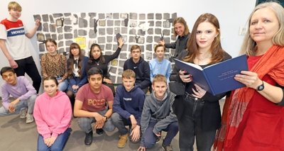 Die Lehrerinnen Susanne Peupelmann (r.) und Katja Hoffmann (3. v. r.), Schülerin Keso Tchanturia (2. v. r.) und ihre Klassenkameraden der 9a der Ohain-Oberschule vor der Collage zum jüdischen Leben in Freiberg. 