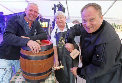 Brand-Erbisdorfs Oberbürgermeister Martin Antonow, Stadtvereinschef Hans-Jürgen Fischer und Enrico Wild von W&W-Events (v. r.) freuen sich beim Fassanstich auf ein schönes Stadt- und Haldenfest am Wochenende. 