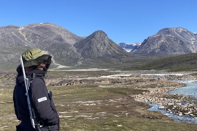 Rangerin mit Netzhut gegen die Mücken. Zum Schutz vor Eisbären ist bei Wanderungen auch immer ein Gewehr dabei wie hier am Camp Frieda.