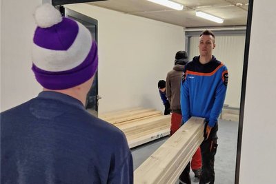 Die Neuhausener Vereinssportler Lucas Haustein und Leon Eckert (v. l.) tragen Materialien für den Prallschutz in die neue Trainingshalle. 