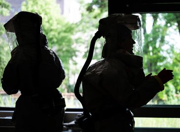 Auf der Isolierstation müssen Mitarbeiter Schutzanzüge tragen.