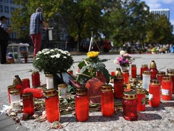 Ein Mann spricht auf einer Gedenkveranstaltung am Tatort, wo ein Chemnitzer bei einer Messerattacke getötet wurde.