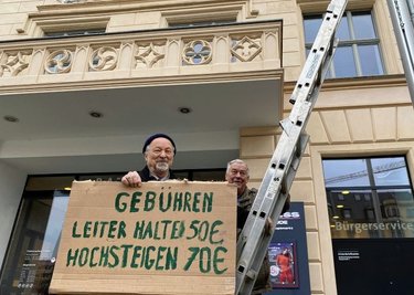 Martin Böttger (links) und Karl-Ernst Müller demonstrieren mit einer Leiter vor dem Rathausbalkon gegen die FDJ-Entscheidung. 